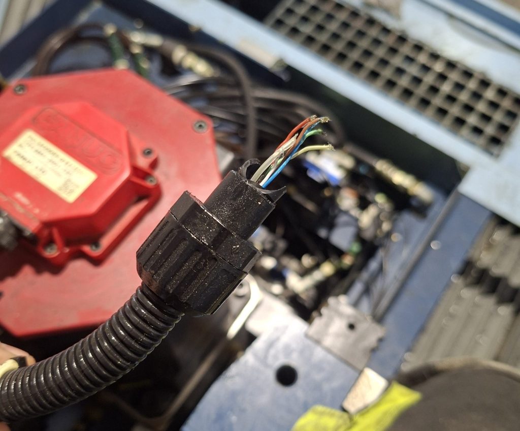 Cable de servo CNC dañado con conductores expuestos que puede provocar alarmas de sobrecorriente