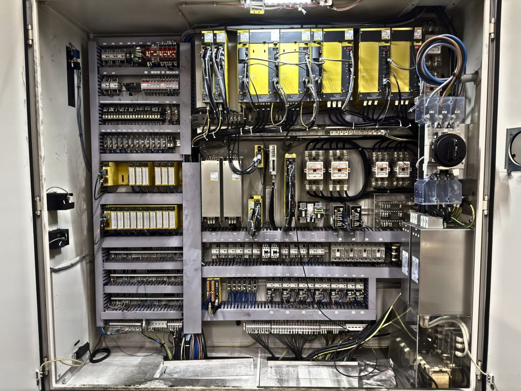Sistema CNC industrial con servo amplificadores y fuente de alimentación en armario eléctrico